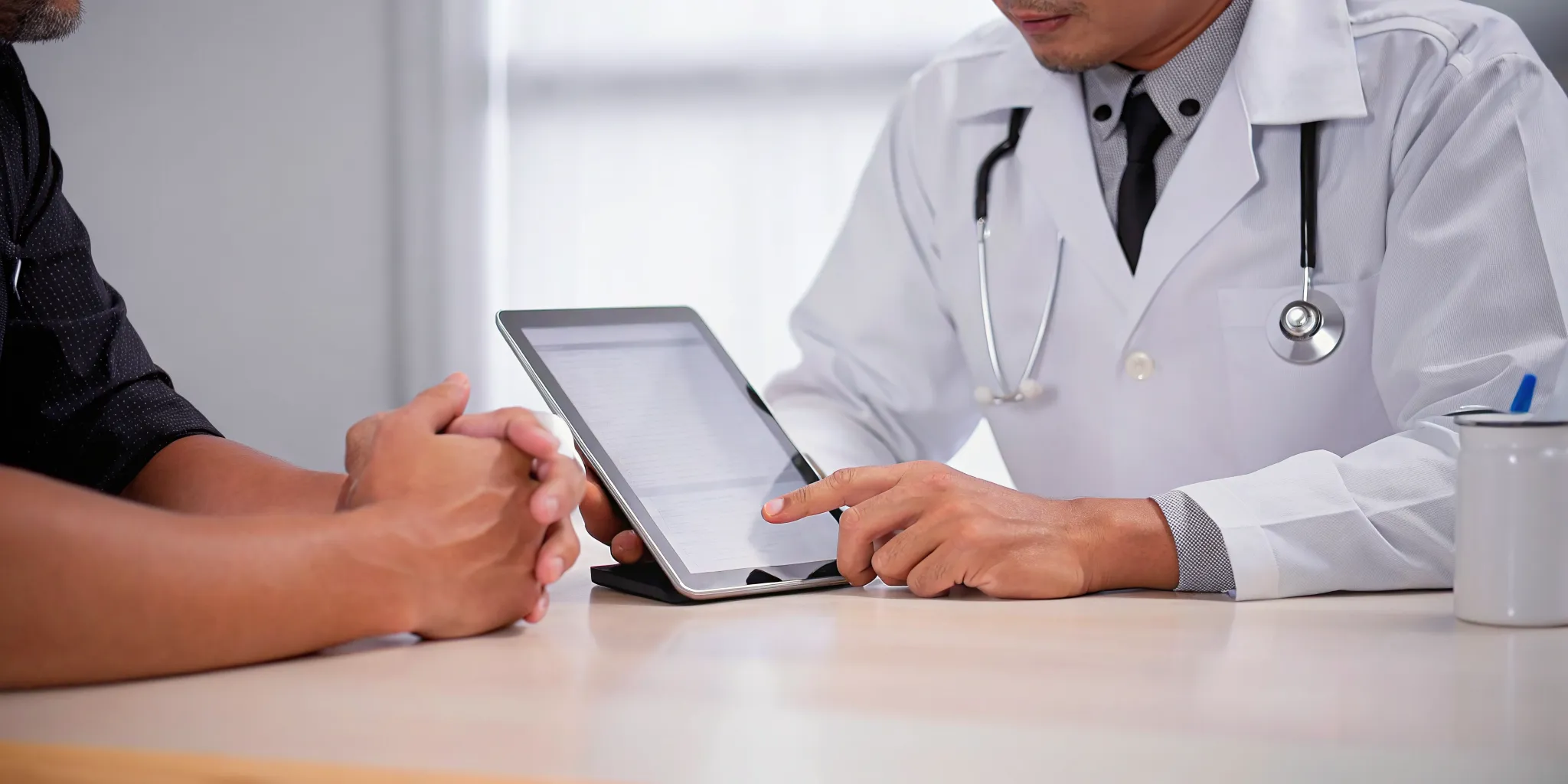 Private doctor reviewing a VA DBQ form on a tablet with a veteran patient.